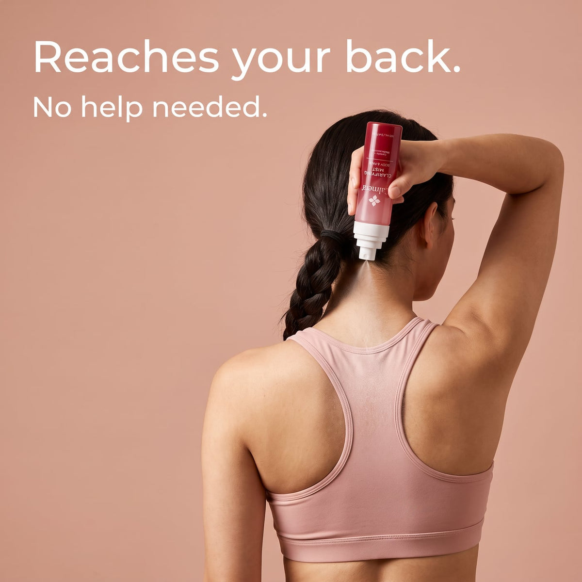 Woman spraying Calmera Clarifying Mist onto her upper back