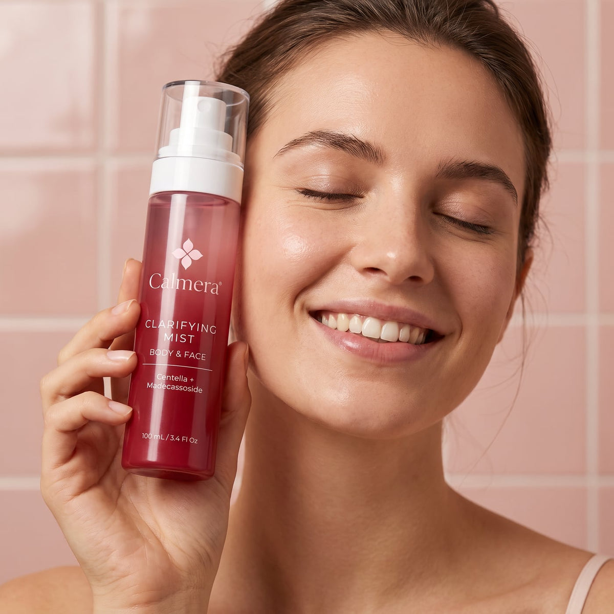 Woman holding Calmera Clarifying Mist beside her face