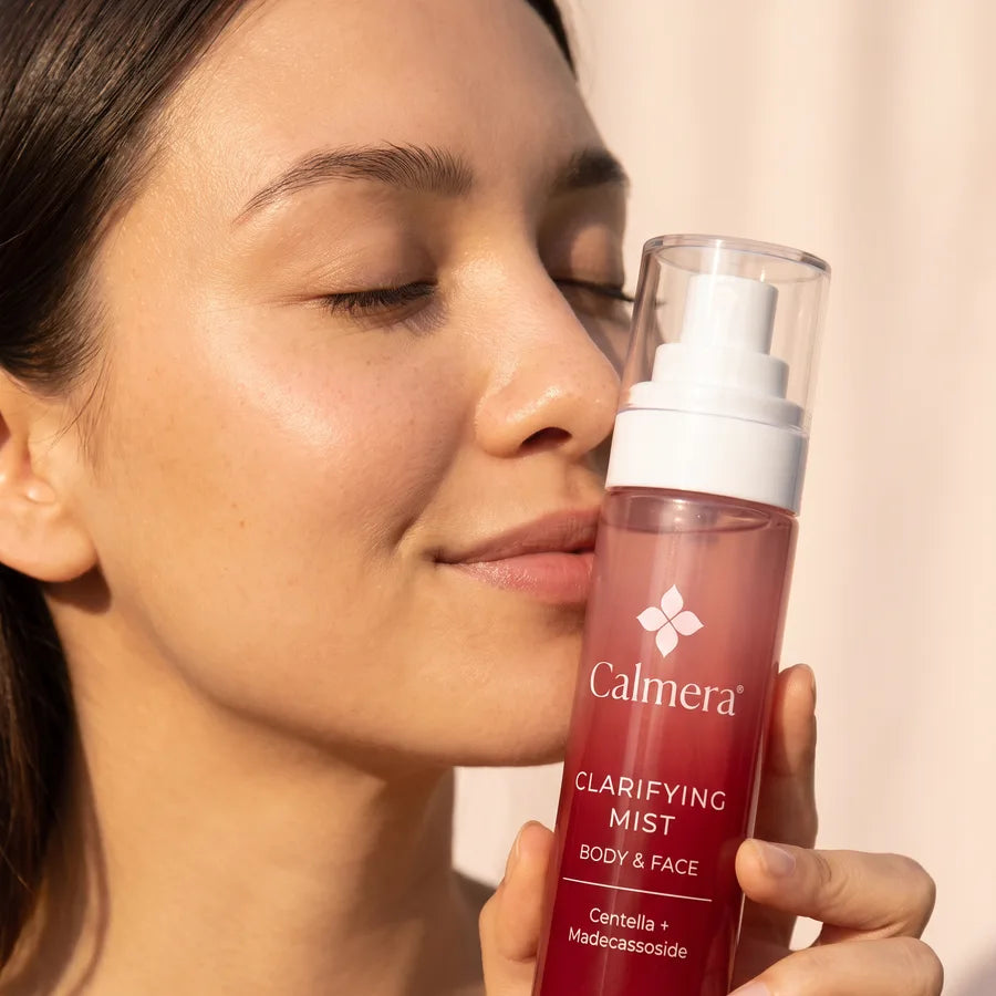 Woman holding Calmera Clarifying Mist to her cheek